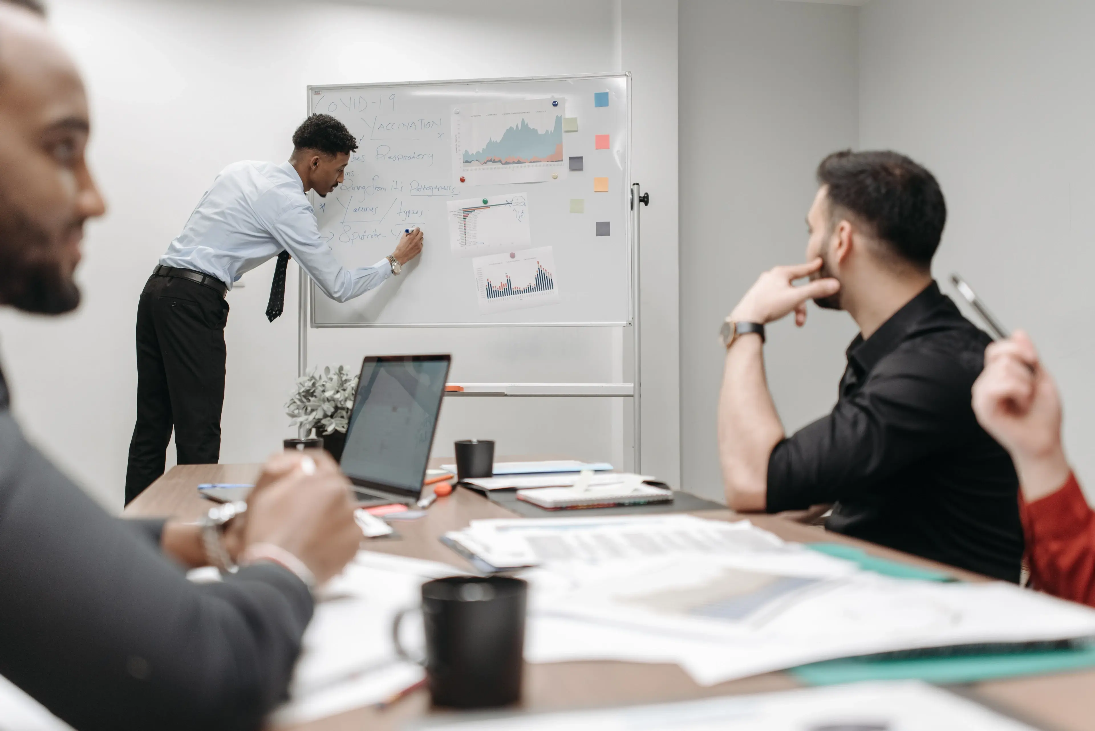 A business analyst facilitating a process mapping workshop at a whiteboard